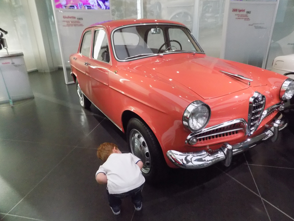 Photo of a child looking at a car